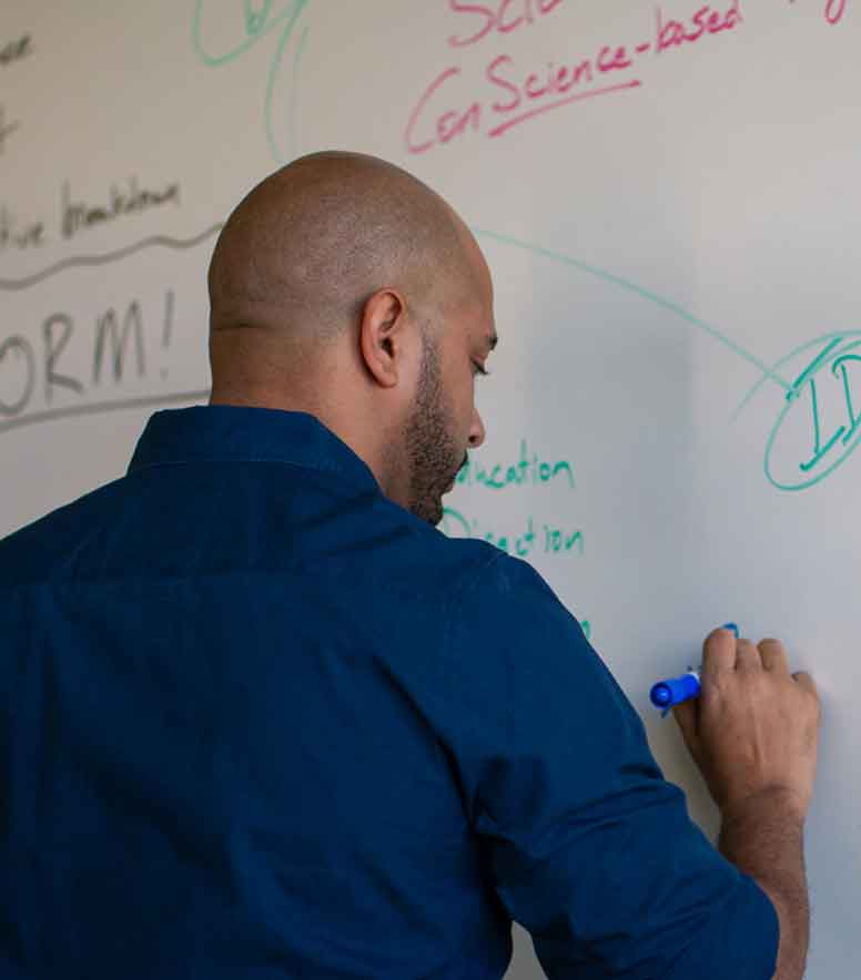 Troy brainstorming on a whiteboard