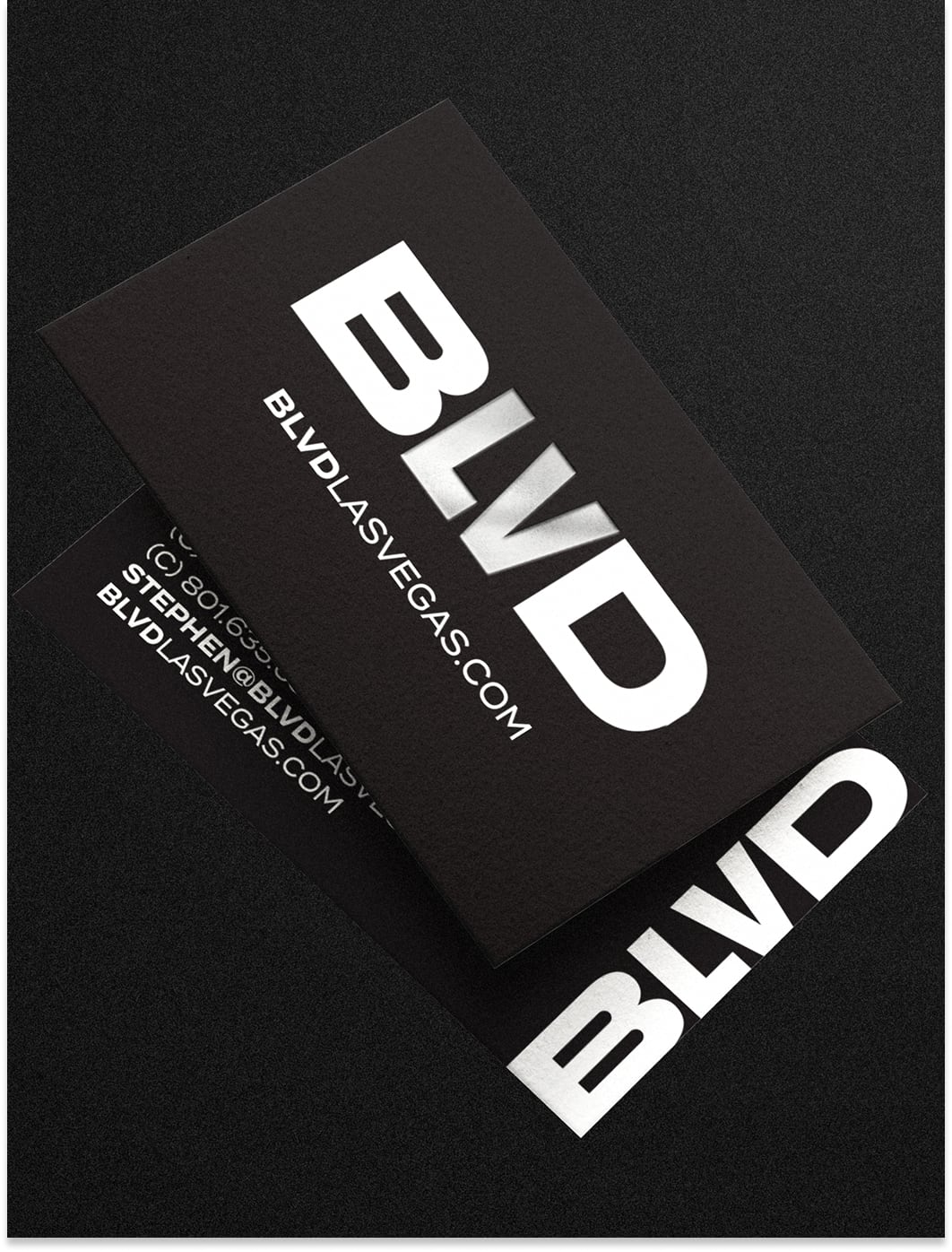 Two black business cards with bold white text reading BLVD and BLVDLASVEGAS.COM on a black surface.