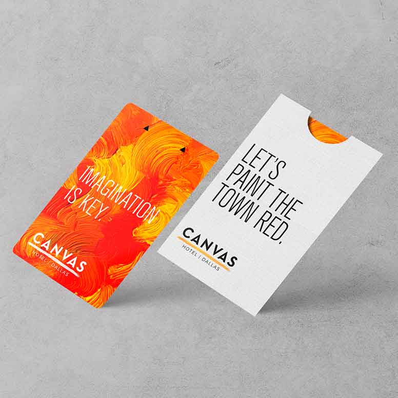 Two hotel key cards: one with orange paint strokes, one white with text, Lets paint the town red.