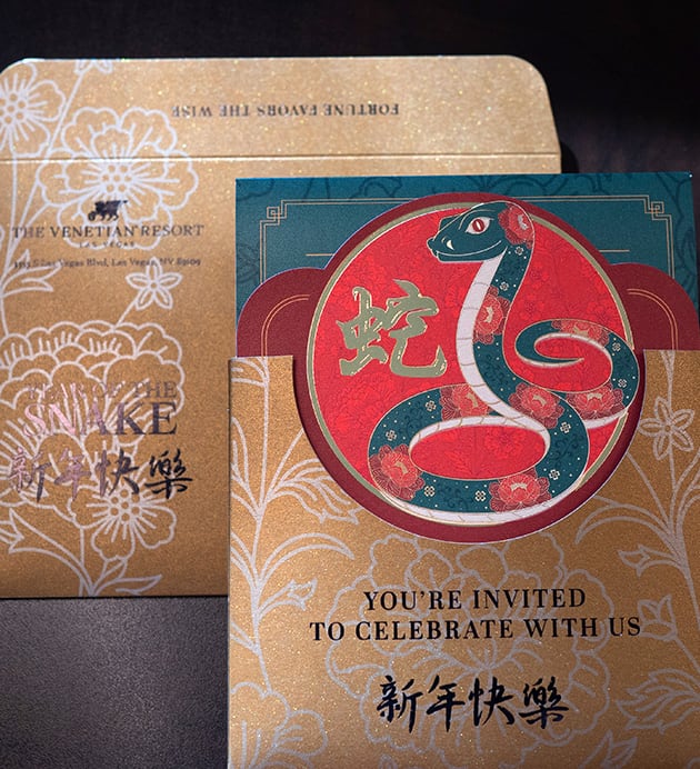 Festive invitation card with a snake illustration and gold floral patterns, celebrating Lunar New Year.
