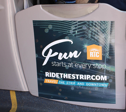 Sign on a bus door reads: Fun starts at every stop. RIDETHESTRIP.COM. Travel the Strip and Downtown.
