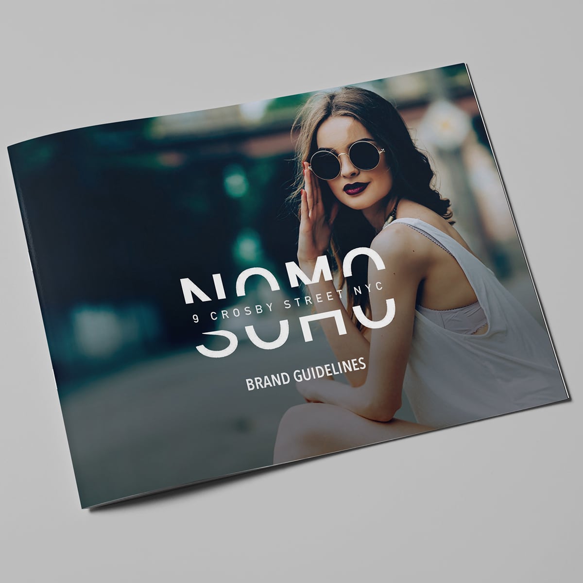 A booklet cover featuring a stylish woman in sunglasses and the text NOMO SOHO Brand Guidelines.