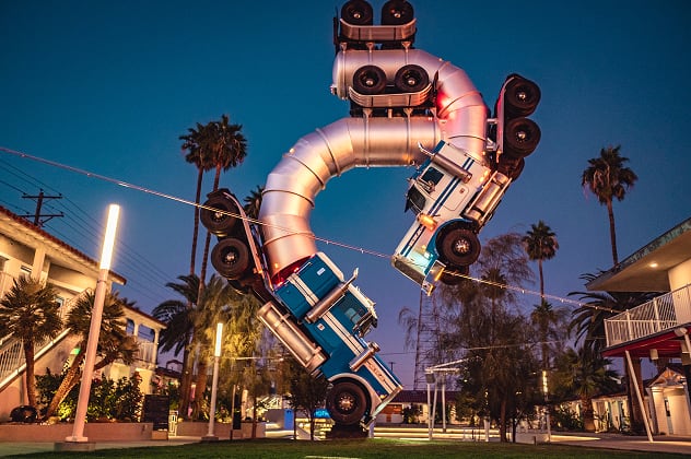 A sculpture of two semi-trucks joined end-to-end to form a loop.