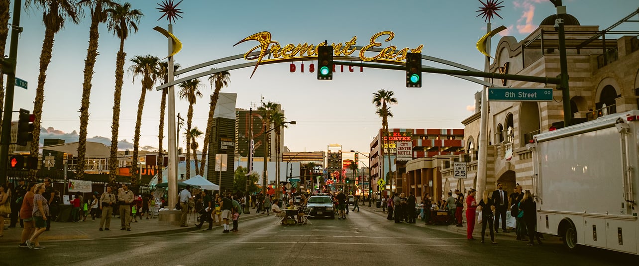 The Fremont East District neon arch over a street in downtown Las Vegas at dusk.