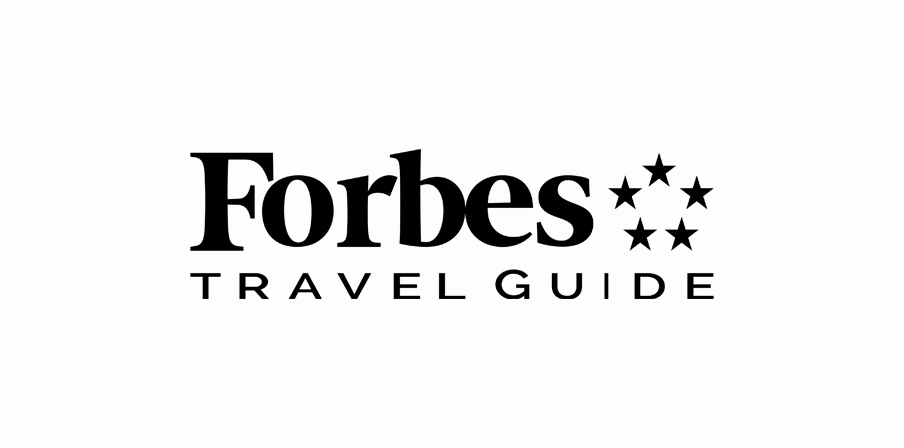 Forbes Travel Guide logo with five stars on a white background.