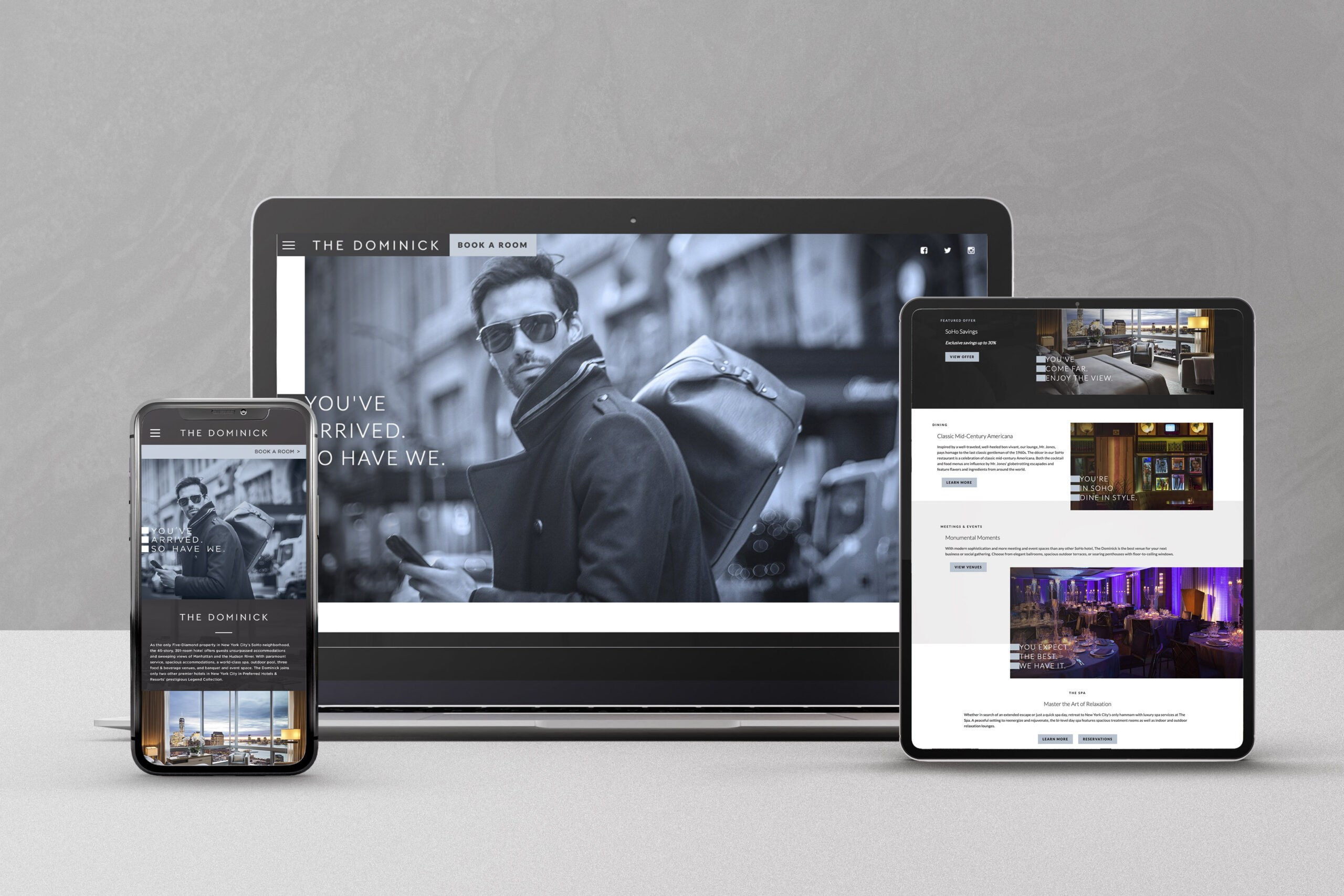 A phone, laptop, and tablet display a hotel website with images of a stylish man and hotel interiors.